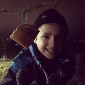 The boy hanging cider toast on an apple tree